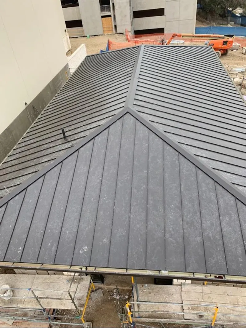 Commercial metal roof construction with crane equipment in Highland Village